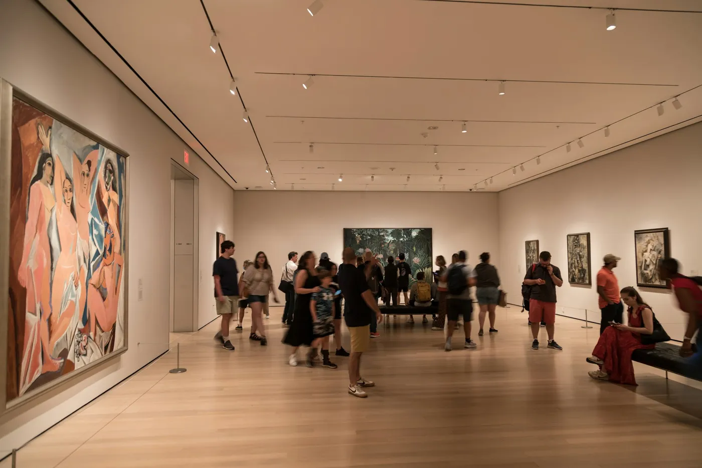 A group of people in a museum looking at paintings