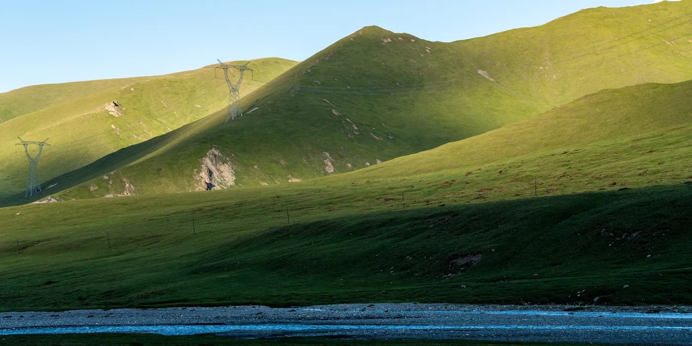 A mountain range with water in the foreground